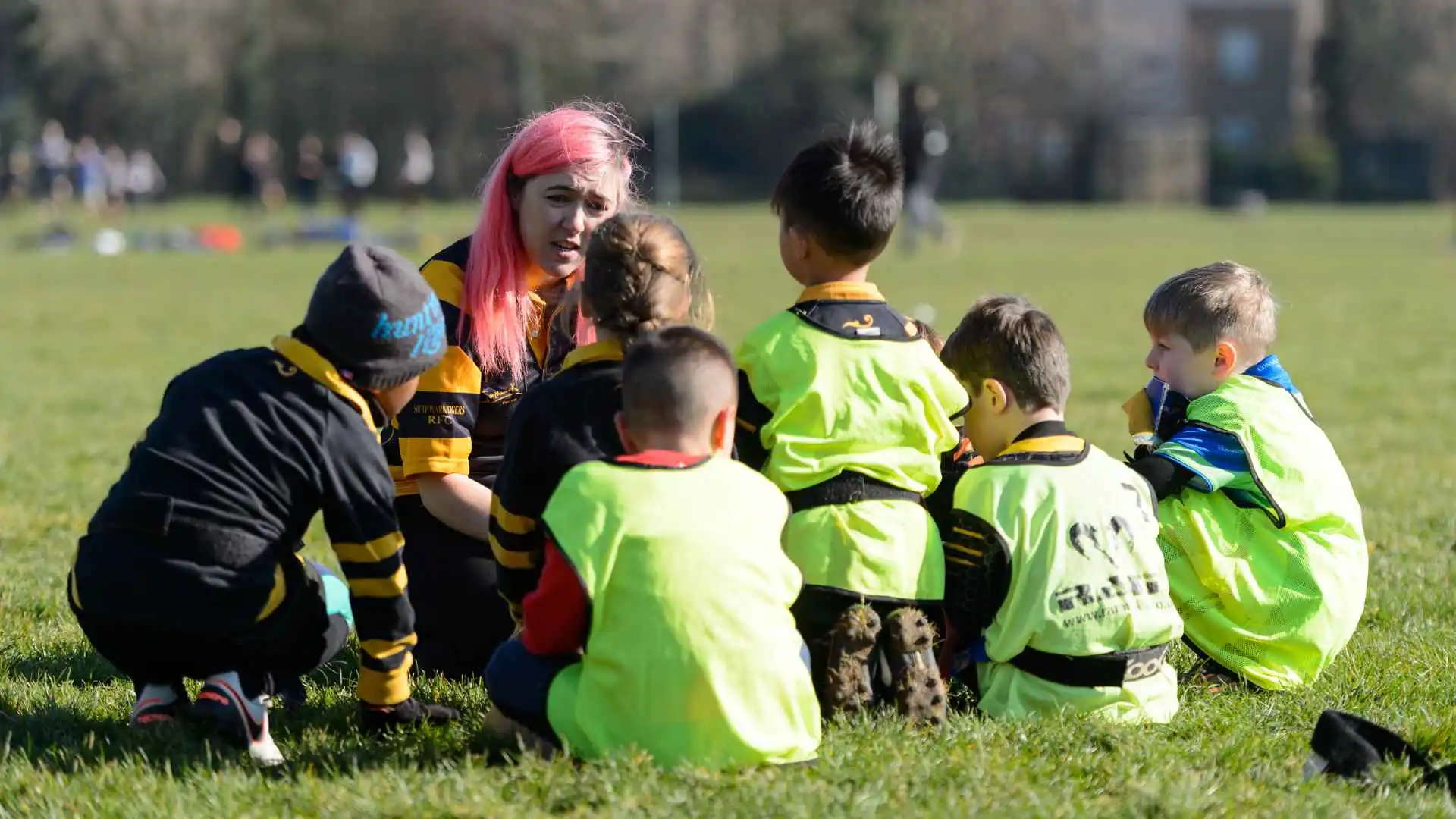 A woman coaching 6 young children