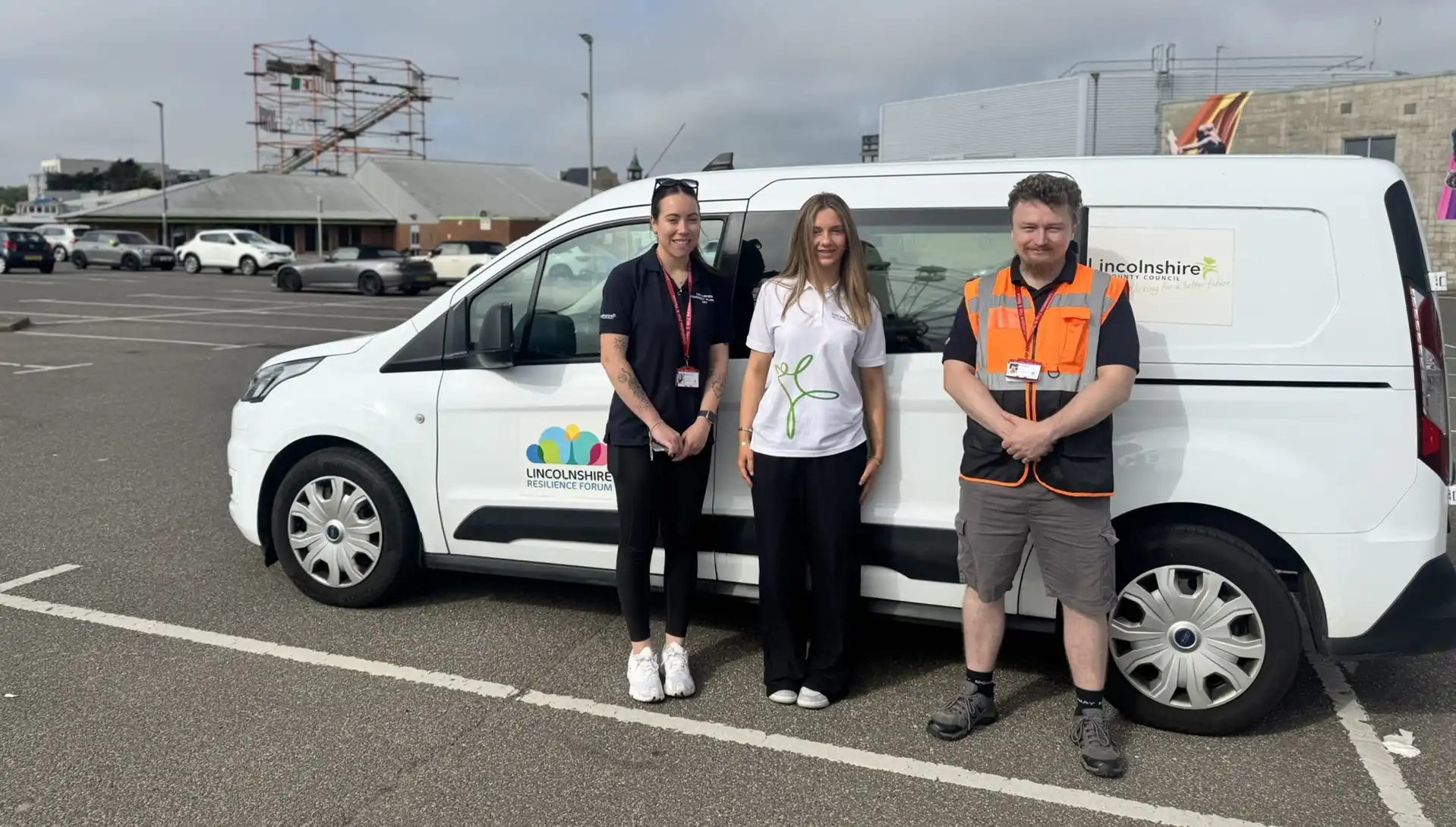 a girl stands between a man and a women, next to a Lincolnshire Resilience forum van.